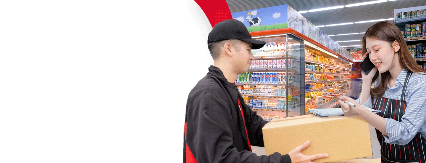 Rider passing parcel to a female employee using her phone in a grocery store.